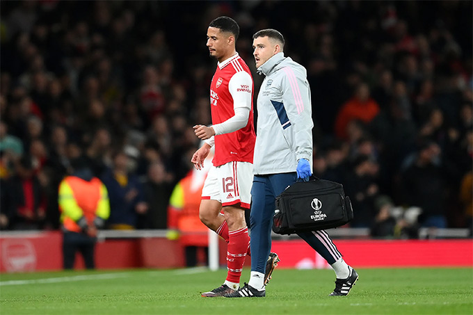 William Saliba rời sân cùng nhân viên y tế Arsenal.